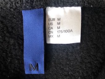Blue and white coloured clothing label displaying medium size